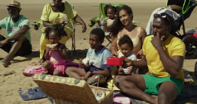 CU WS Family with children (12-17 months, 2-3, 6-7, 8-9) having picnic on beach