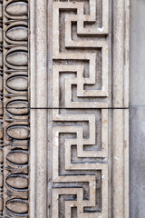 Detail from a wall with ancient Greek style bas relief carvings on marble