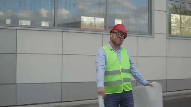 the engineer holds pieces of a torn drawing in his hands and dances