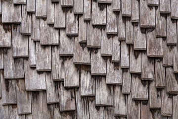 Close up texture background of a wall covered with wooden shingles