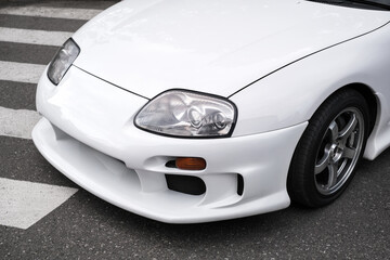 Obraz na płótnie Canvas front headlight of white sport car close-up