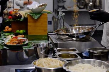 A thai chef cooking a pad thai during a masterclass. Paris, France.