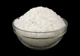 Salt in glass bowl on black background close up