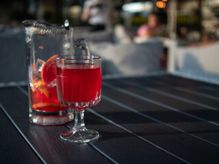 Homemade Lemonade, cold drink with red orange juice, glass and jug on the table
