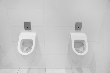 Two white man urinals in a public toilet