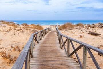wooden walkways, access to La Barrosa beach in Sancti Petri, Cadiz, Spain - obrazy, fototapety, plakaty