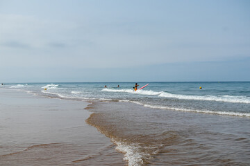 students learning to surf at La Barrosa beach in Sancti Petri, Cadiz, Spain