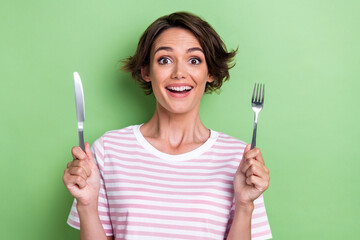 Photo of cheerful pretty lady arm hold silver knife fork waiting tasty meal restaurant impressed...