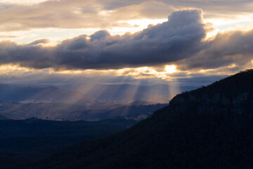 Obraz premium Ray of light passing through the clouds into the valley.