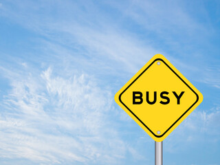 Yellow transportation sign with word busy on blue color sky background