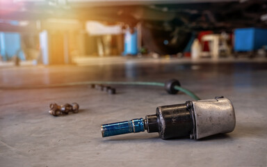 Electric drill to loosen the bolts of vehicle wheel for changing a car tire in garage.mechanic...