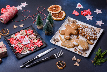 Obraz na płótnie Canvas Christmas decorations and gingerbreads on a dark concrete table. Getting ready to celebration