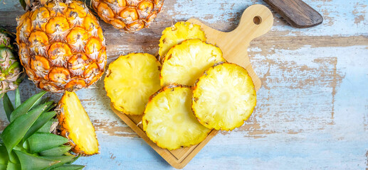 Top view of Sliced and half Pineapple and fresh pineapple fruit placed on an old wooden background