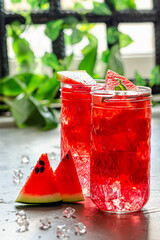 watermelon drink in a glass with ice on the table against the background of the window in the backlight