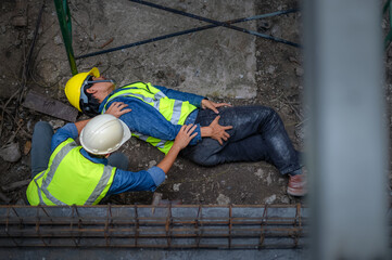 A young Asian builder falls from a scaffold at a construction site. An engineer supervising the...