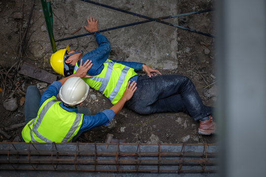 A young Asian builder falls from a scaffold at a construction site. An engineer supervising the construction came to the aid of a construction worker who fell from a height with hip and leg injuries.