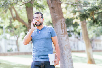 handsome businessman using his smartphone in park