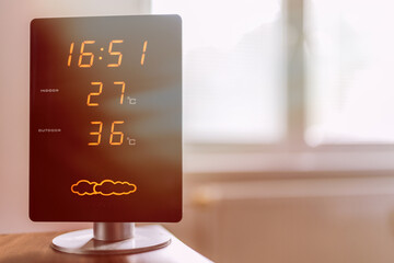 Display of home meteo station showing high interior and exterior temperature during hot summer day