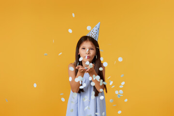 birthday child girl blowing confetti off her hands