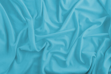 light blue abstract background of fabric with wrinkles and waves for product presentation