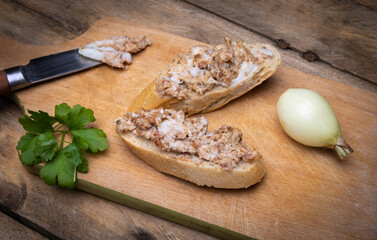 Sandwiches with rillettes, meat pate on a wooden cutting board. Rustic composition with spread meat...