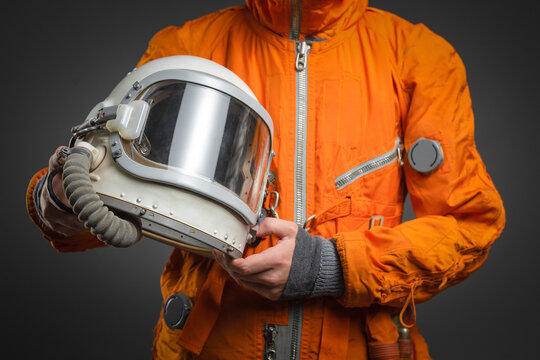 Space helmet in the astronaut hands close up. Cosmic tourism concept.
