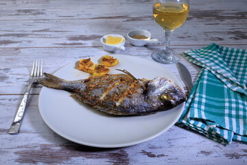 A composition with grilled fish and white wine for dinner.