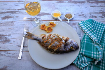 A composition with grilled fish and white wine for dinner.