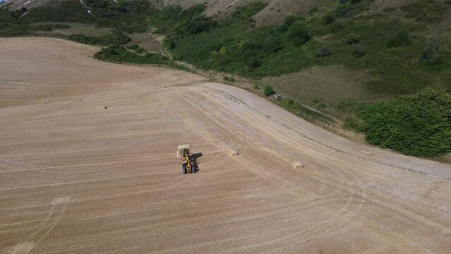 British Agricultural and Harvesting Fields Farms at Sunset Time. High Angle Footage taken with drone's camera on a hot summer day of England. Agricultural Farms and Working Machines at Dunstable Downs