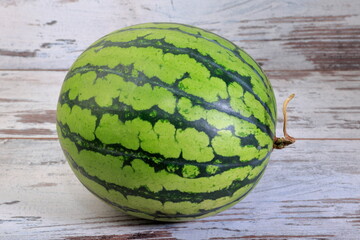 Fresh whole watermelon composition on wooden background.