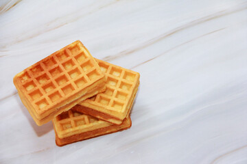 belgian fluted baked sweet waffles on a gray marble background