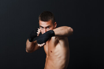 Fototapeta na wymiar Sportsman muay thai man boxer stance at black background.