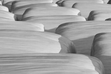 Obraz premium Faded black and white background of plastic wrapped hay bales 