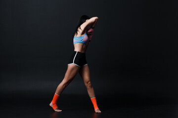 Fototapeta na wymiar Sportsman muay thai woman boxer posing in training studio