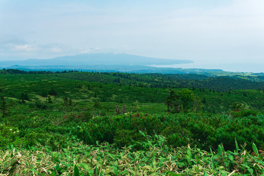 typical landscape of the southern Kuriles, view of Kunashir Island from the slope of Golovnin volcano, Mendeleyev volcano is visible in the distance in the haze