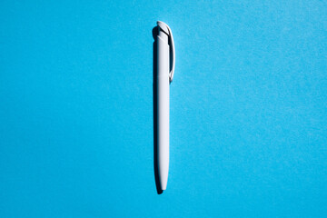 white pen in the center on a blue background