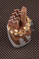 Chocolate extreme milkshake with brownie cake, chocolate paste and sweets. Crazy freakshake food trend. Copy space