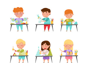 Fototapeta premium Happy cute little boys and girls painting and cutting paper crafts at lesson set cartoon vector illustration
