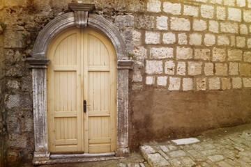 Fototapeta na wymiar An old yellow door on a stone street