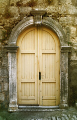 An old yellow door on a stone street