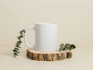 Mockup mug with copy space and eucalyptus leaves on wooden stand.