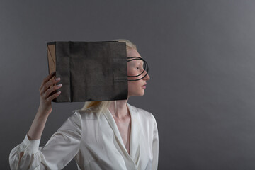 White caucasian albino blond woman holds shopping bag. Sale and discounts on market and Black...