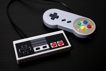 Retro gamepads on a black background. Old school console controllers, videogames pads.