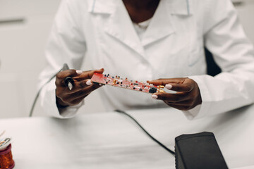 Scientist african american woman working in laboratory with soldering iron. Research and...