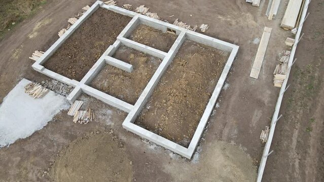Top down aerial view of building works of new house concrete foundation on construction site