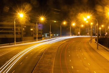 View from the bridge to the night highway with traces of car headlights.