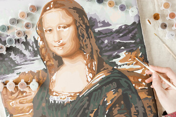 Painting by numbers with acrylic paints. Woman coloring Mona Lisa picture by numbers, hand with brush and colored paints on linen tablecloth on table. Creative hobby, leisure at home.