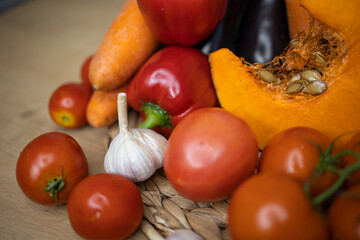 Close-up of autumn vegetables a piece of pumpkin, tomato on a branch, red pepper, garlic, carrot. Menu for a healthy diet or thanksgiving Recipe Ingredients. 