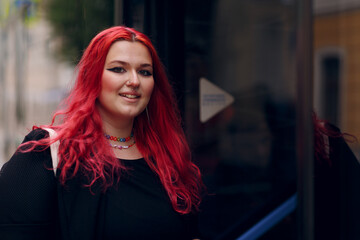 European plus size woman gets on the bus. Young red pink haired body positive girl.