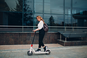 Young woman with electric scooter at the city. © primipil